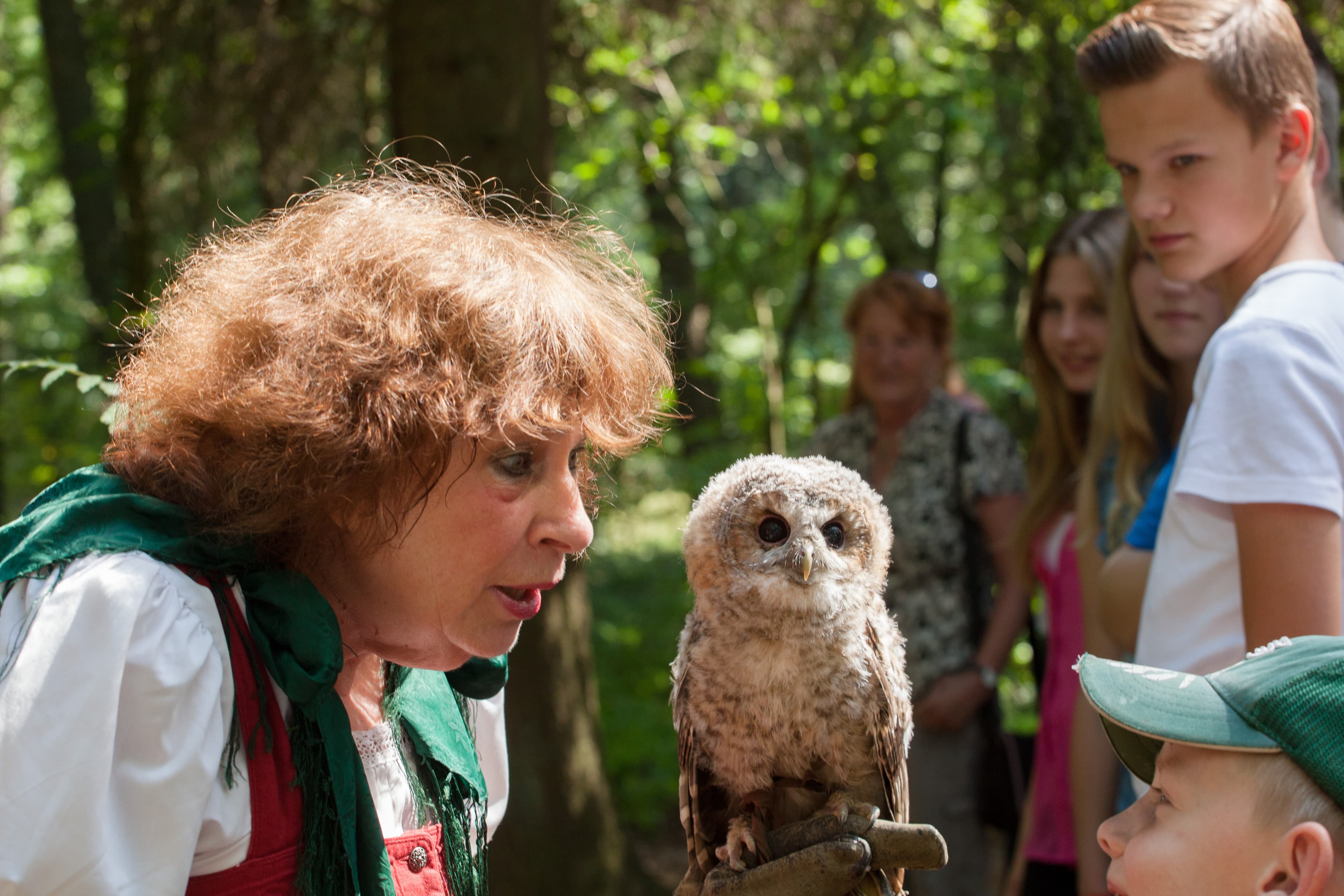 Frau präsentiert Kindern einen Greifvogel
