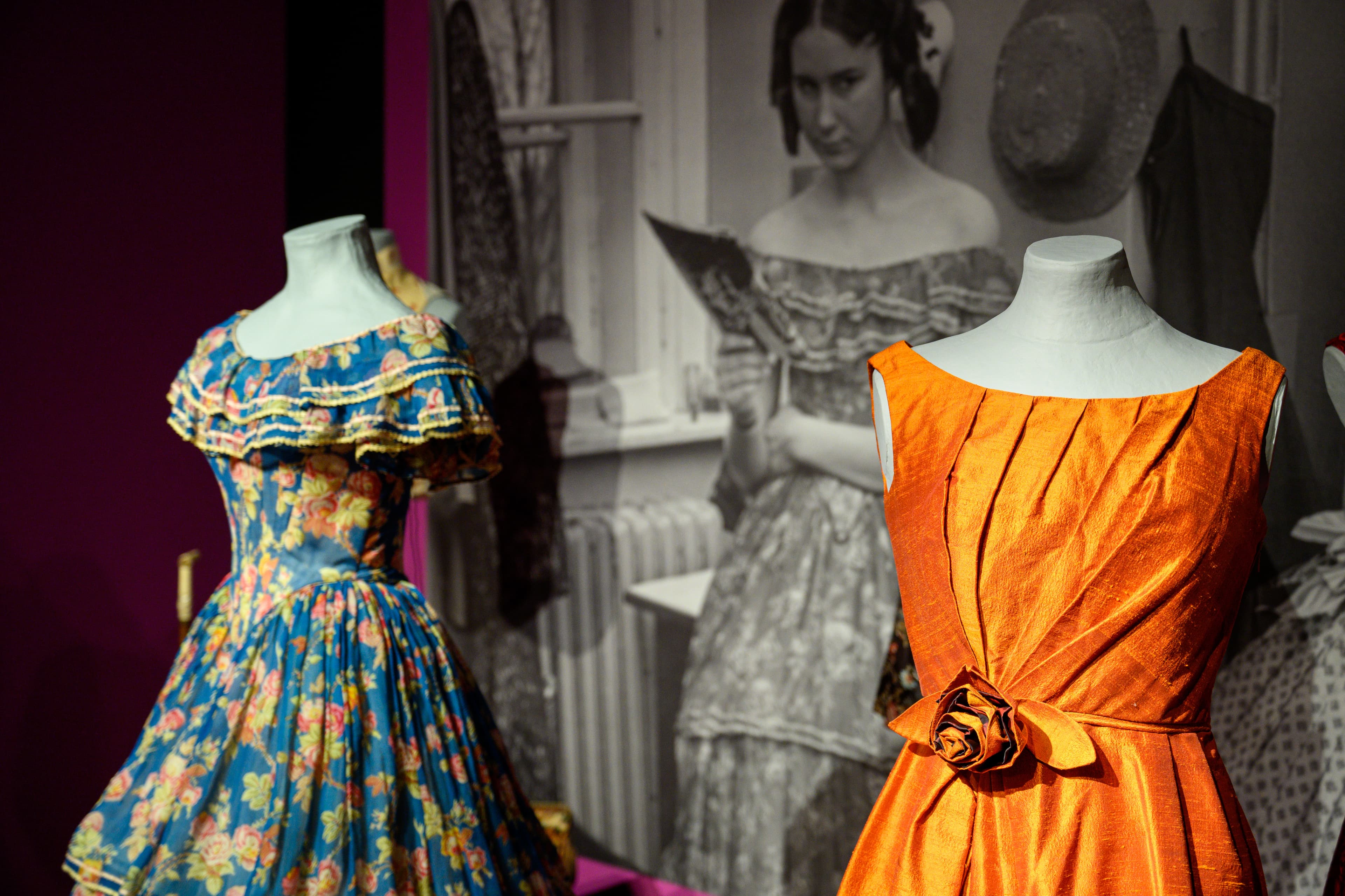 Ausstellung im Bomann-Museum: Mannequins in einem blauen Blumenkleid und einem orangen Kleid.