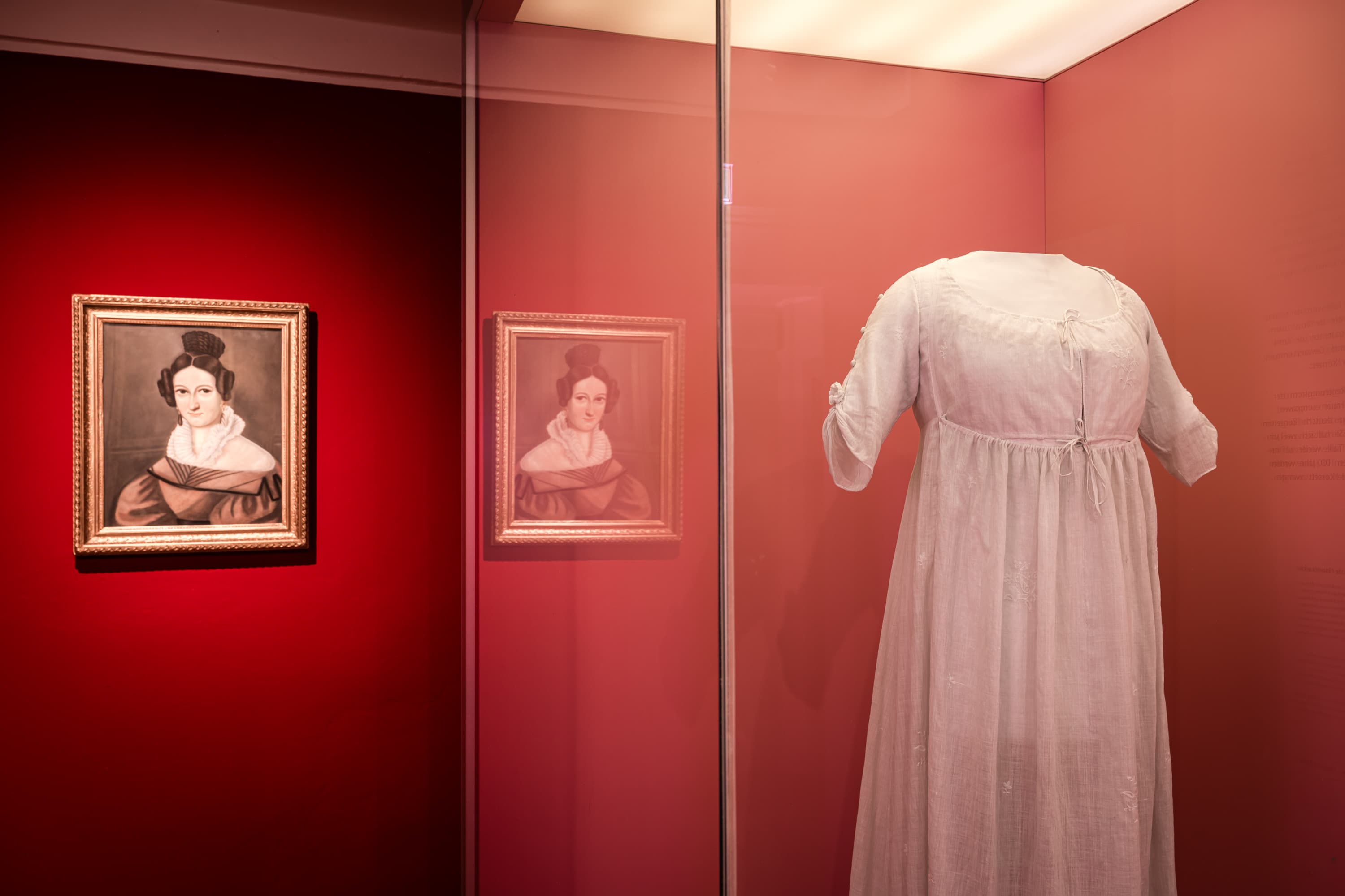 Modeausstellung im Bomann-Museum: Ein historisches, helles Kleid neben einem Damenporträt.