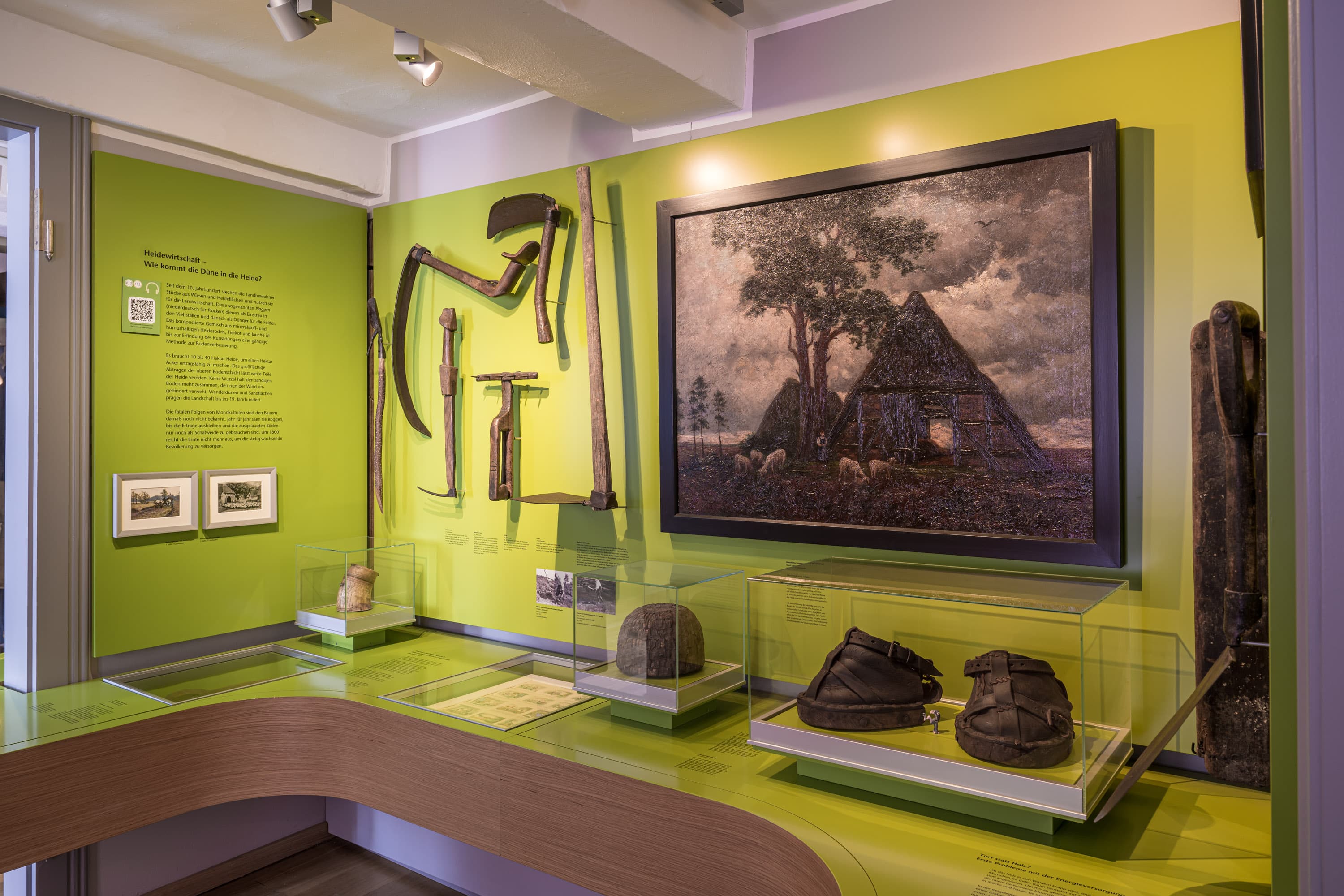 Einblick in die Ausstellung zur Heidewirtschaft mit Werkzeugen, Gemälde und historischen Objekten.