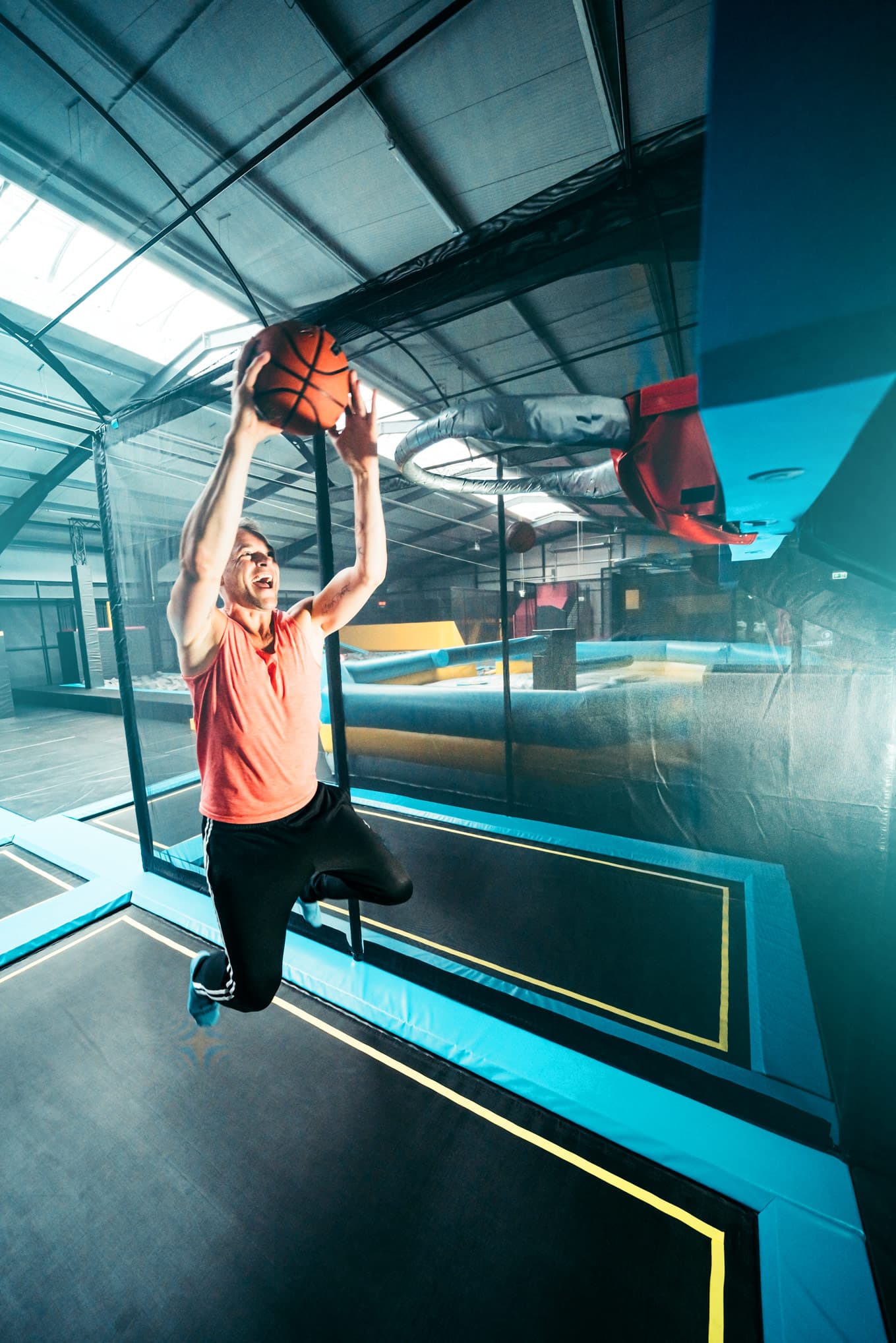 Mann springt mit Ball auf Trampolin im Abenteuerland Bispingen, ideal für Familien.