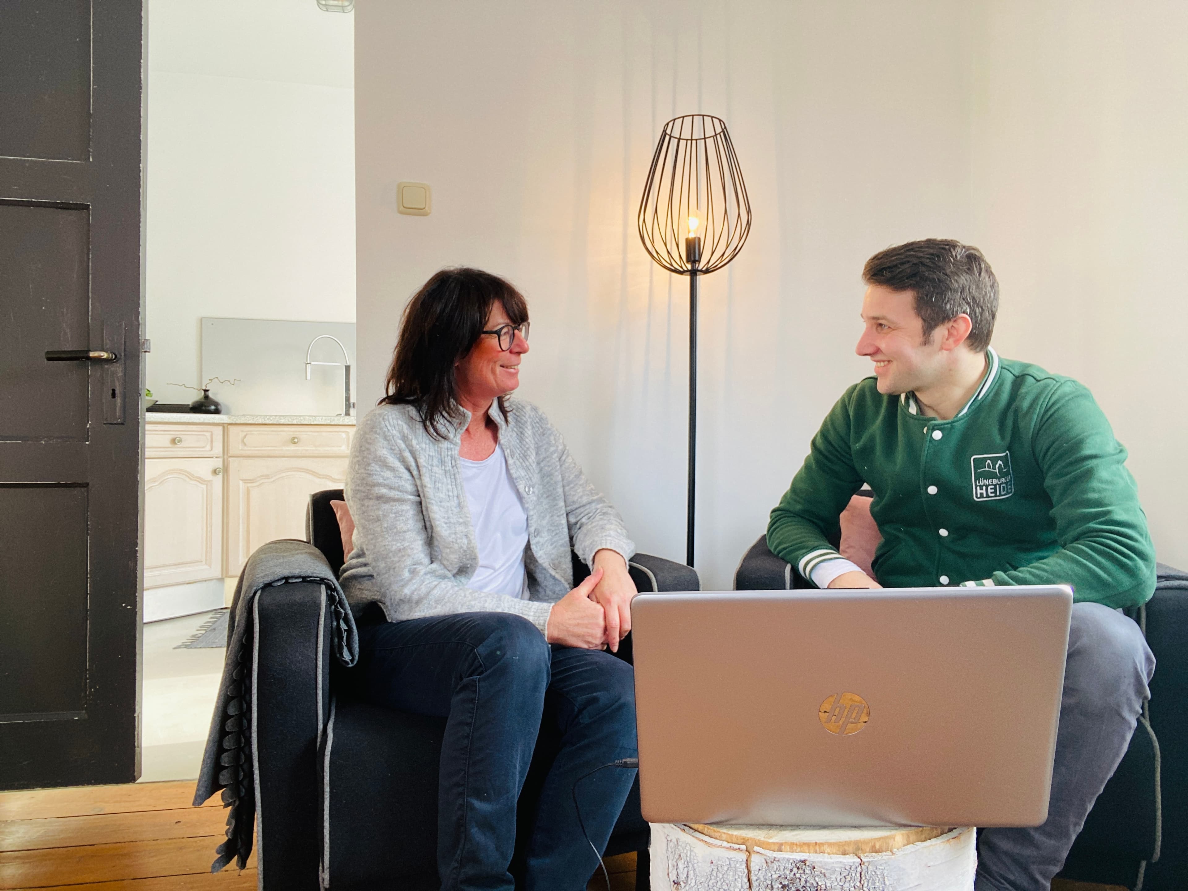 eine frau und ein mann sitzen nebeneinander auf zwei sesseln und unterhalten sich