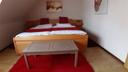 Das gezeigte Bett hat die Größe 1,80 x 2,00 m und verfügt über eine einteilige Matratze.