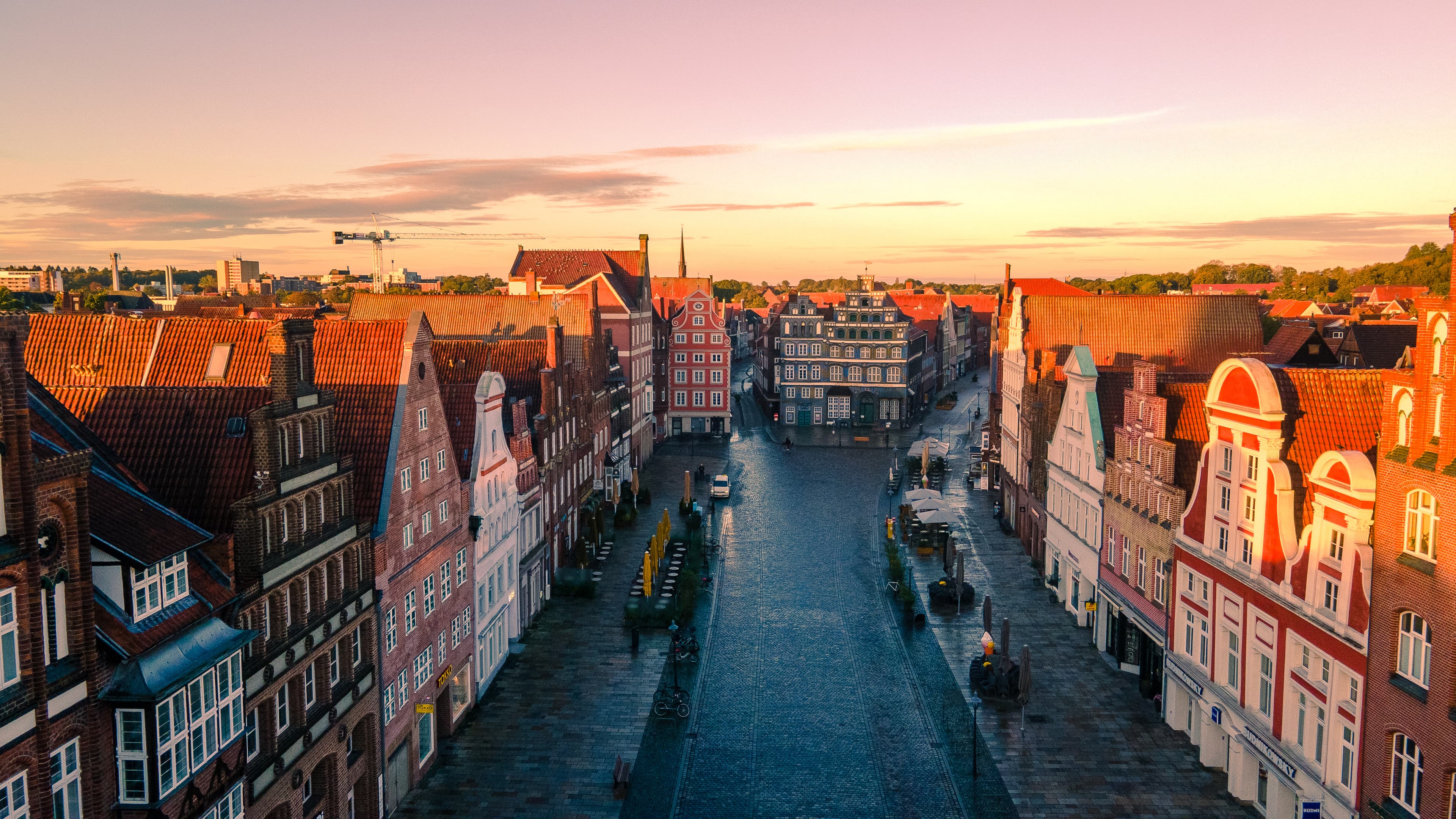 Historischer Platz Am Sande in Lüneburg mit markanten Giebelhäusern im warmen Sonnenlicht.
