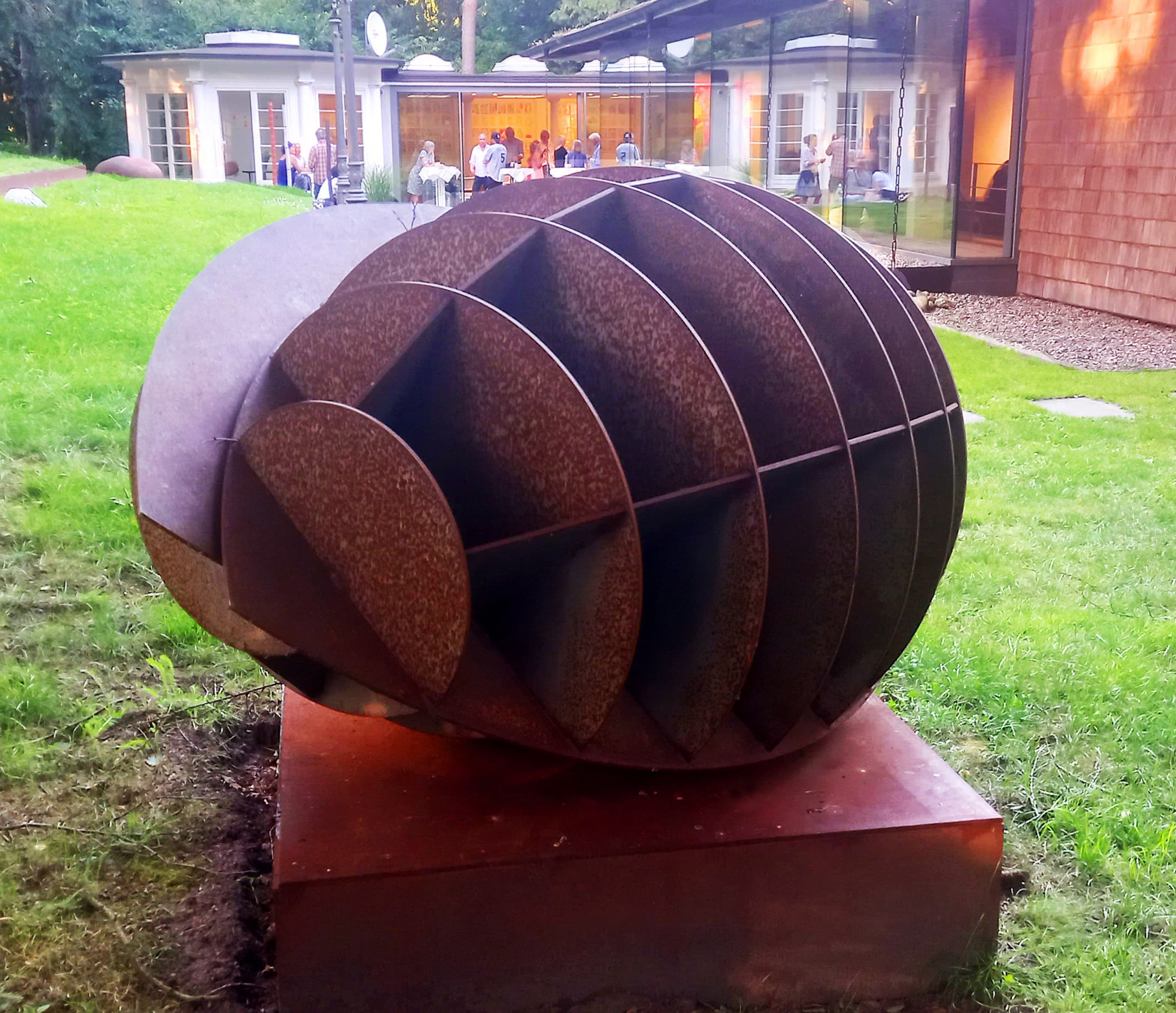 Das Bild zeigt eine faszinierende moderne Skulptur von Harald A. Finke im Jahr 2022, die organische Formen verkörpert und das Zusammenspiel von Chloroplasten und Mitochondrien thematisiert.