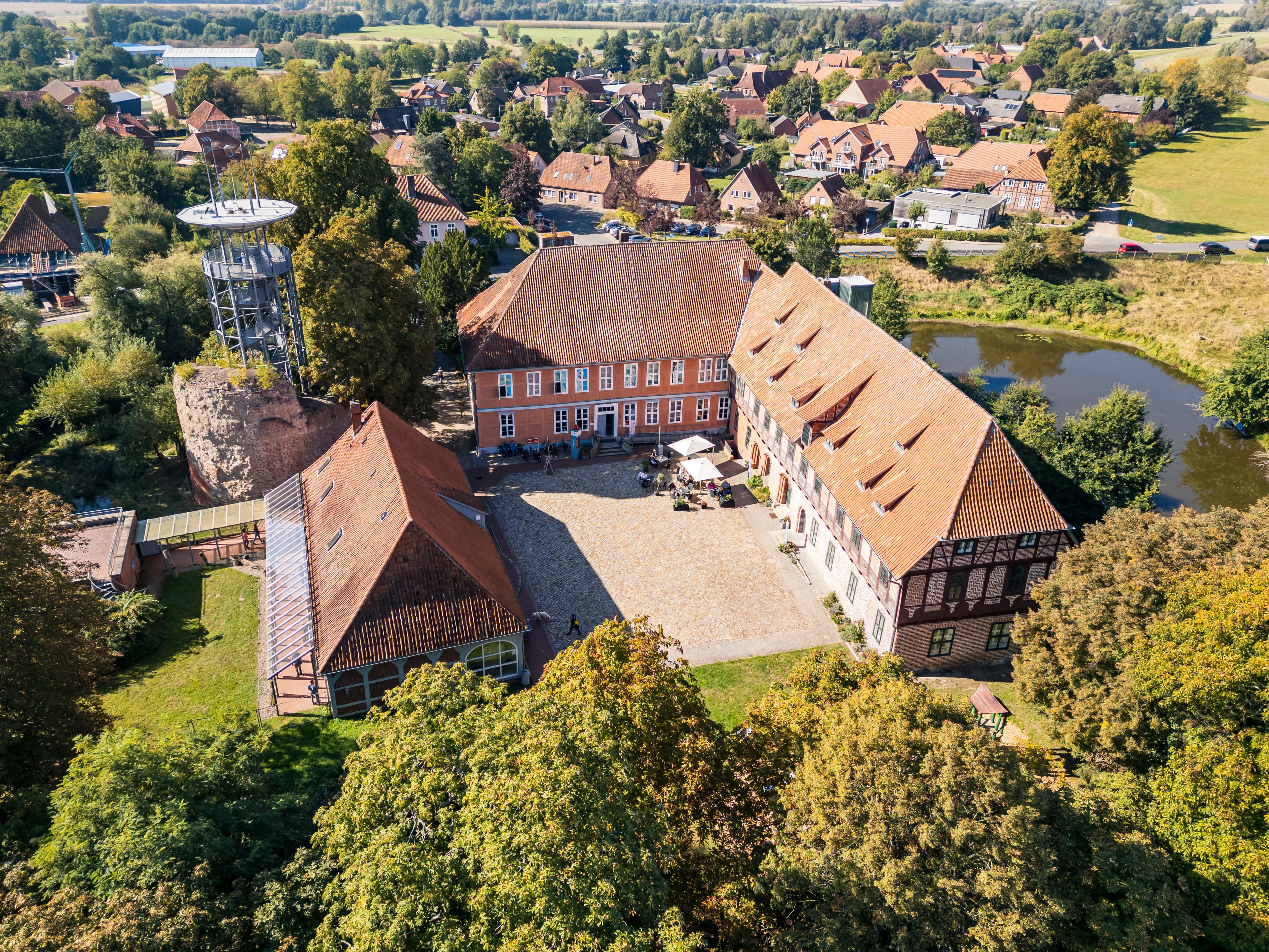 Drohnenaufnahme vom Schloss Bleckede mit Aussichtsturm und Café Herr Biber im Innenhof