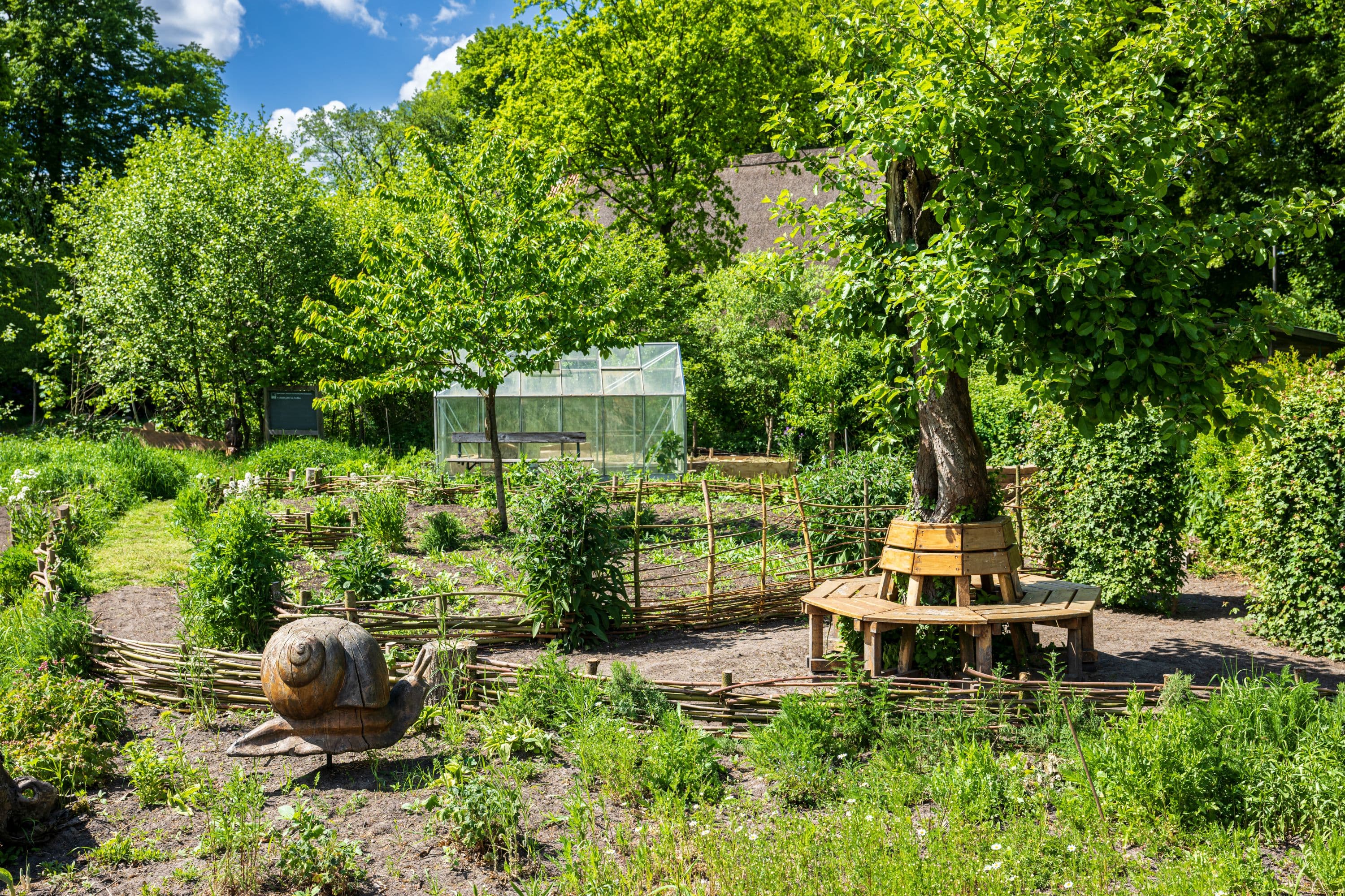 Bänke und Gewächshaus im Garten im Frühling in Buchholz in der Nordheide