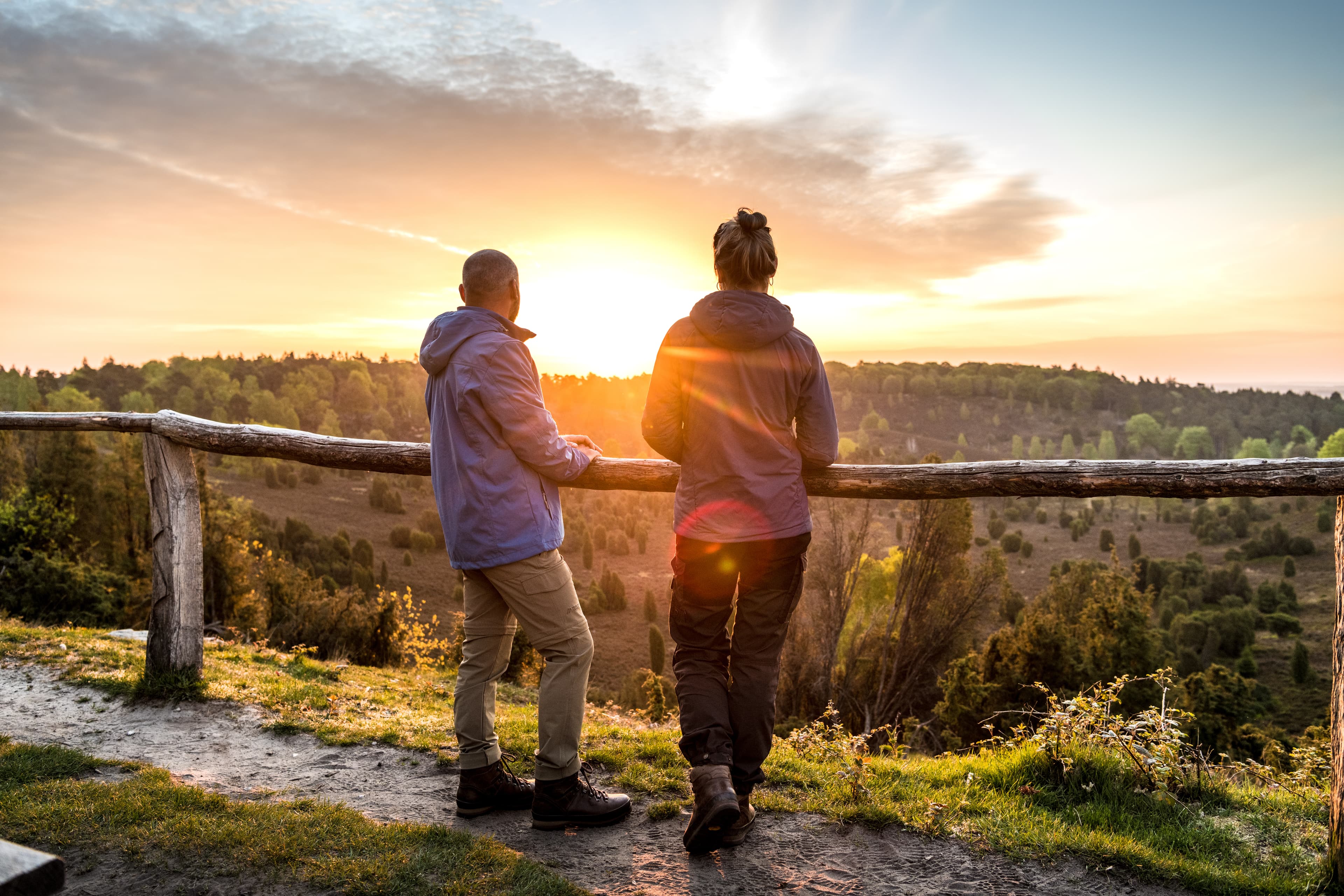 Wanderer in der Lüneburger Heide schauen über die weite Landschaft