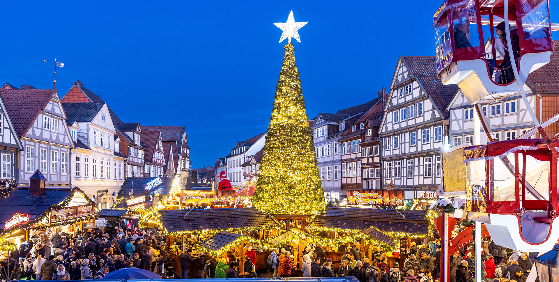 Weihnachtsmarkt in Celle: Leuchtender Tannenbaum, umgeben von Fachwerkhäusern und Menschenmenge.Christmas market in Celle: A glowing Christmas tree, surrounded by half-timbered houses and crowds of people.Julemarked i Celle: Et lysende juletræ omgivet af bindingsværkshuse og masser af mennesker.Kerstmarkt in Celle: Een gloeiende kerstboom omringd door vakwerkhuizen en mensenmassa's.