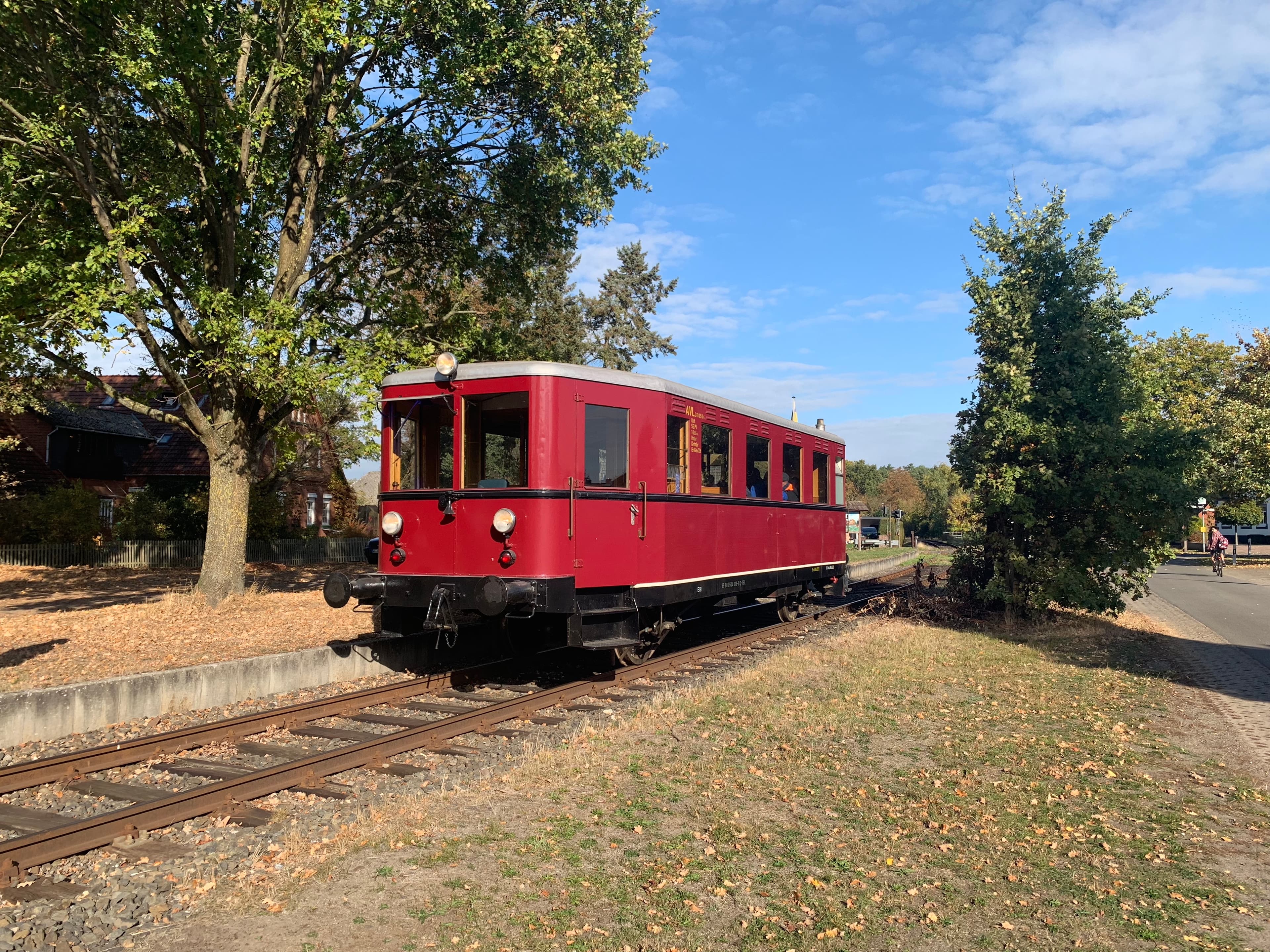 Ein sehr alter roter Triebwagen auf einer eingleisigen Strecke