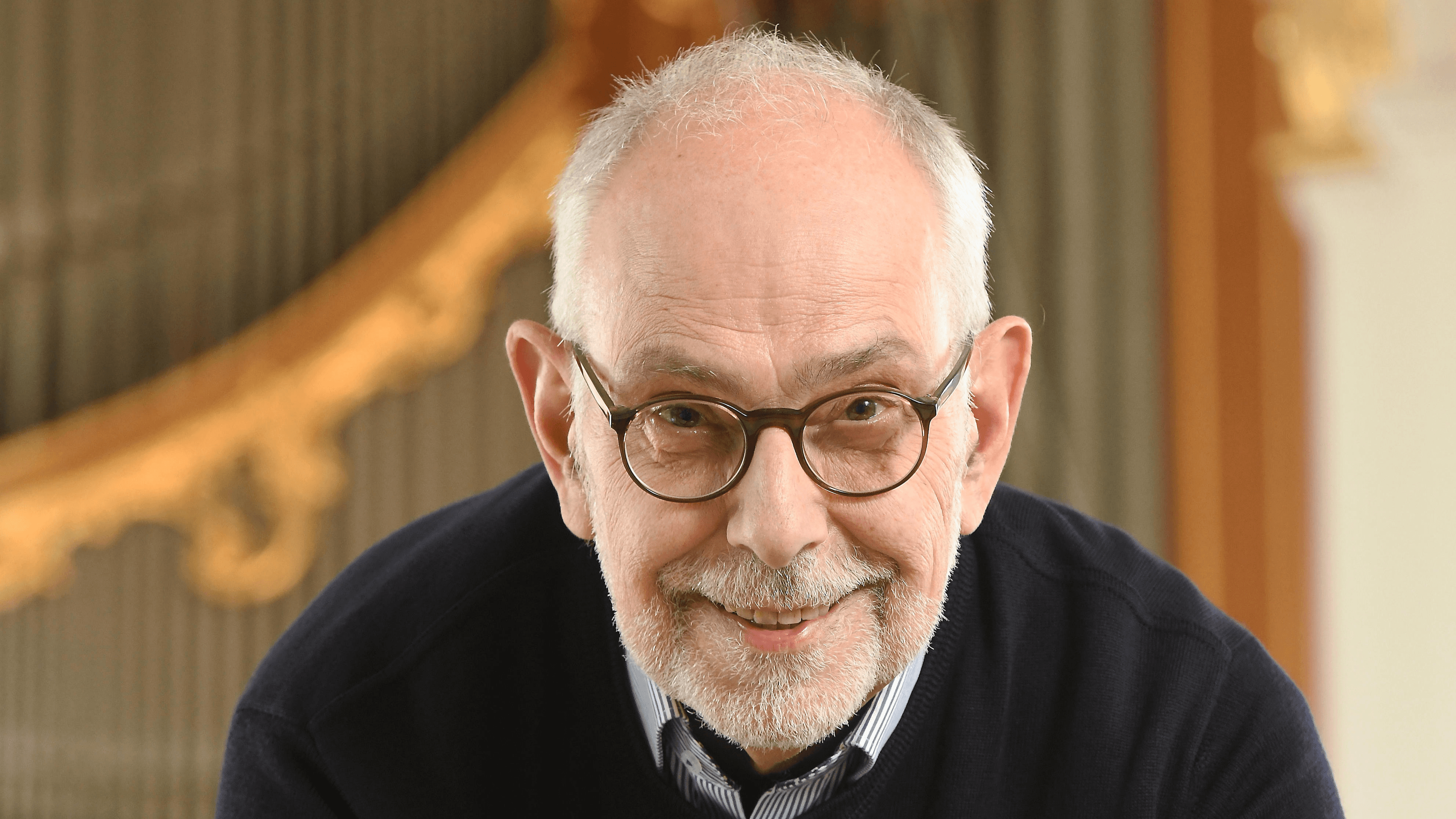 Christoph Schoener lächelt entspannt und stützt sich auf den Spieltisch einer großen Kirchenorgel.