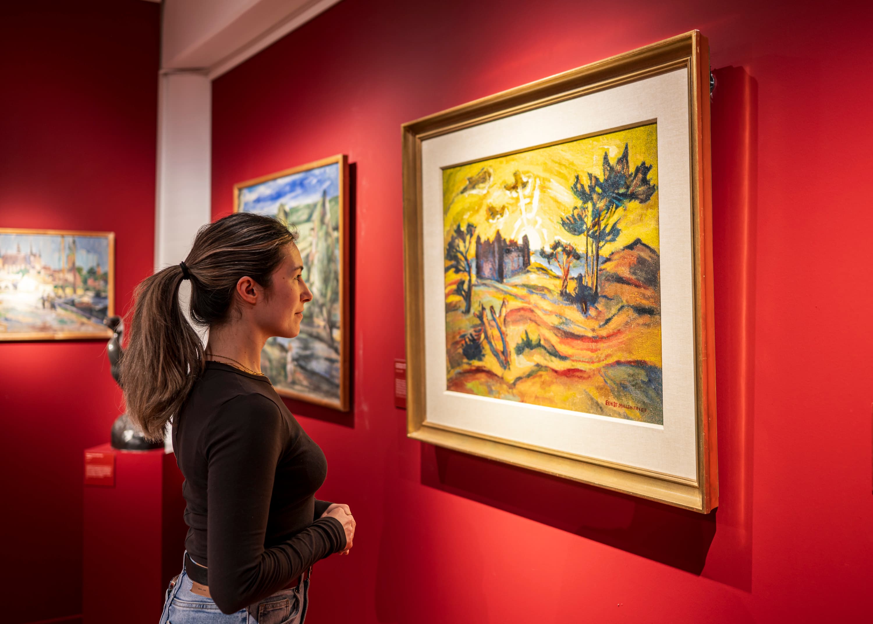 junge Frau steht vor einem gemalten Bild aus Ostpreußen