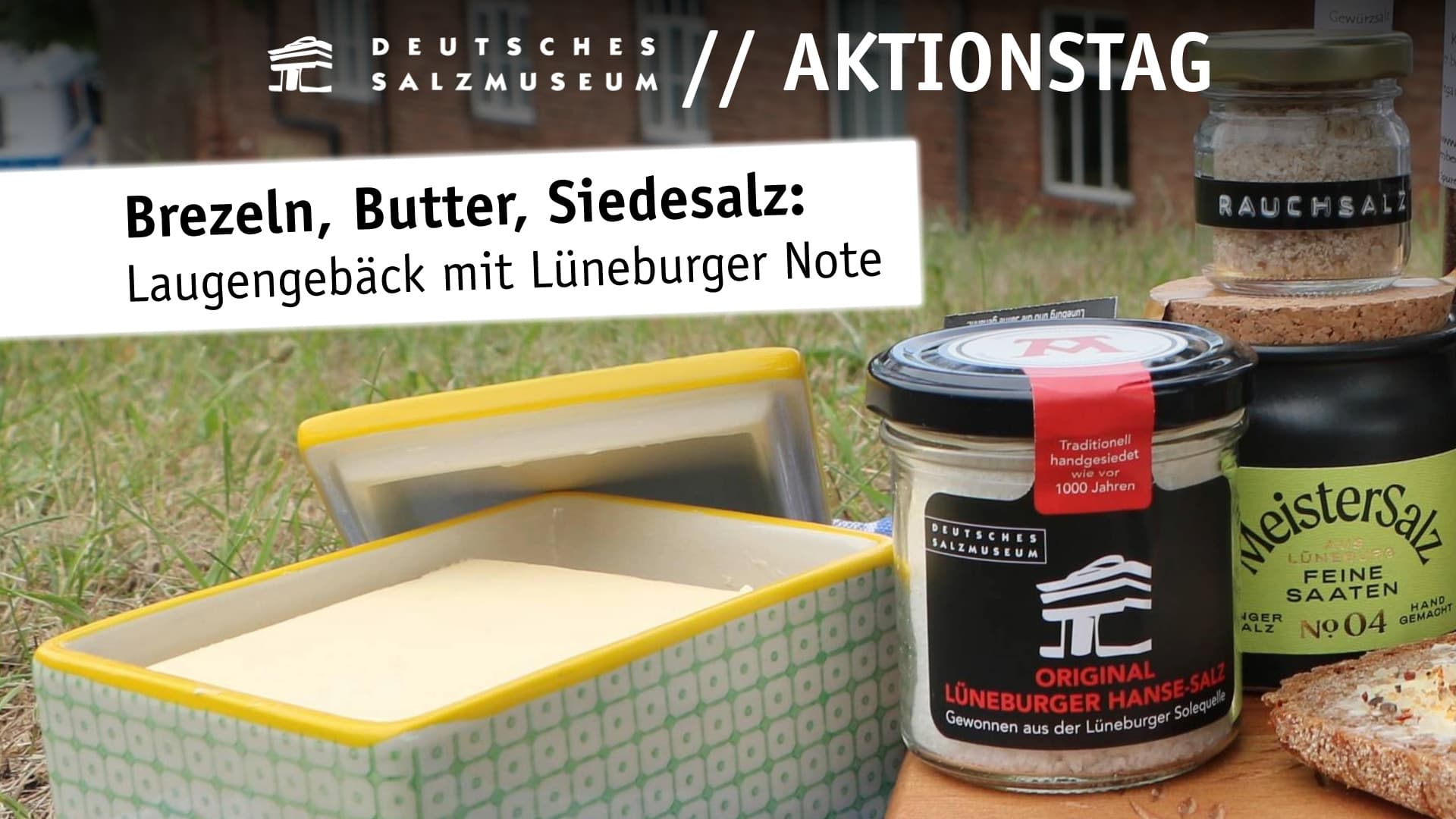 Butterdose, Gläser mit Salz und Brot auf einem Brettchen auf der Wiese vor dem Salzmuseum