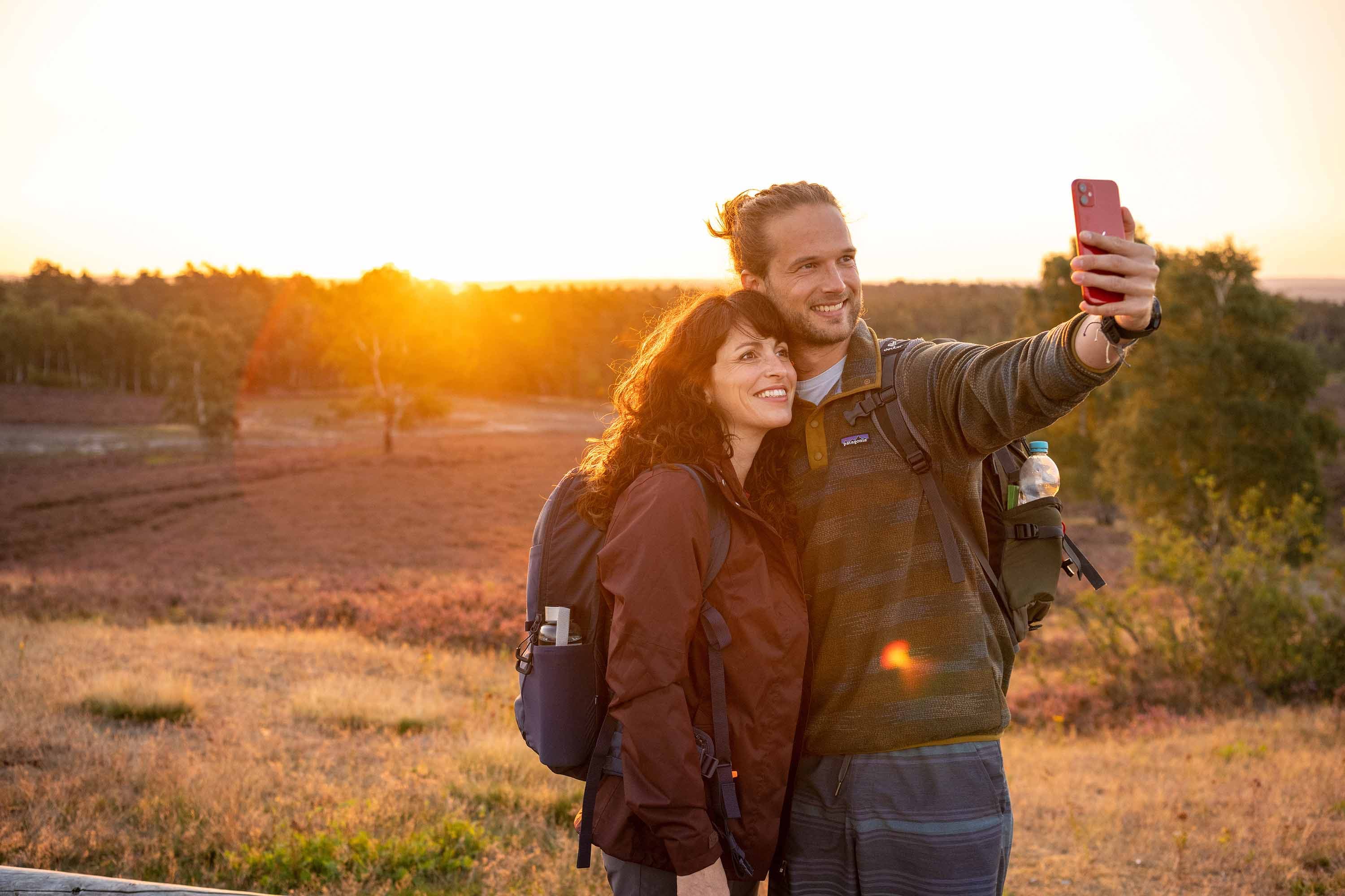 Paar macht ein Foto in der Abendsonne bei den Lüneburger Heide Wandertagen