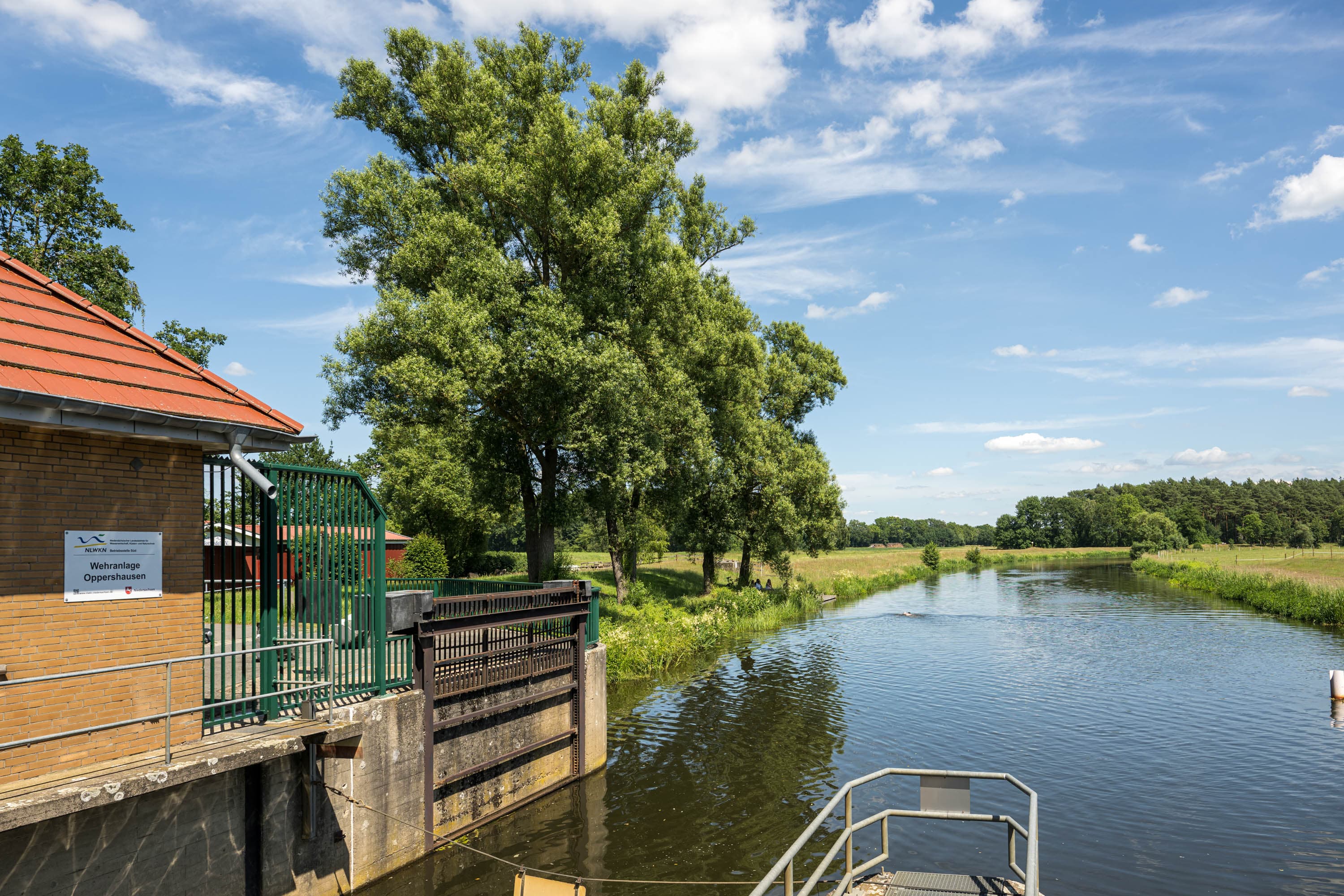 Schleuse am Aller-Radweg mit Wehranlage, Fluss, Wiesen und Bäumen bei Oppershausen