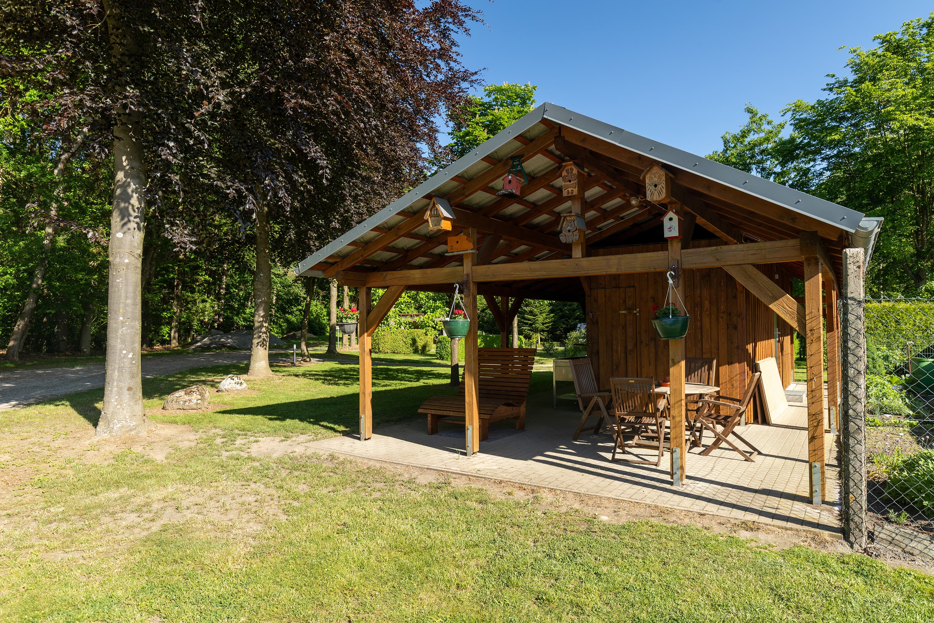 Überdachter Aufenthaltsbereich mit Tisch und Stühlen auf dem Wohnmobilstellplatz Zum Becklinger Holz