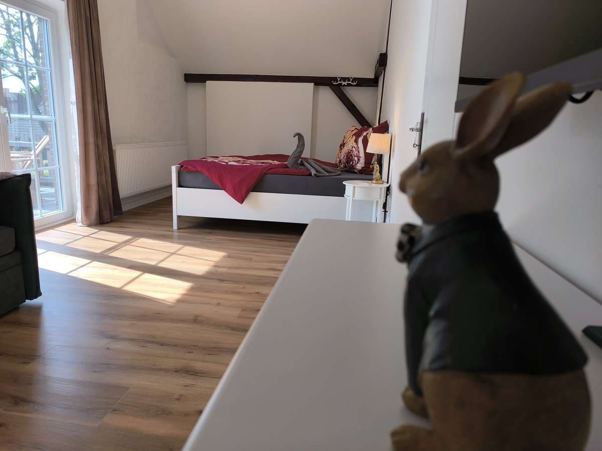 Balkonzimmer unterm Dach mit Doppelbett und Osterhase der die Gäste begrüßt