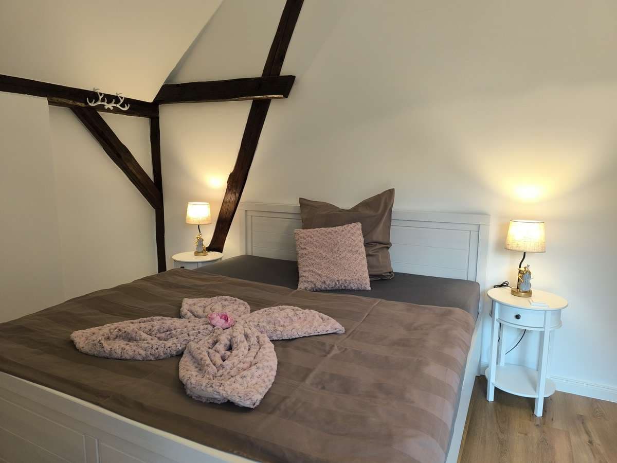 Doppelbett mit taupefarbener Decke und Handtuch-Schwänen im Balkonzimmer
