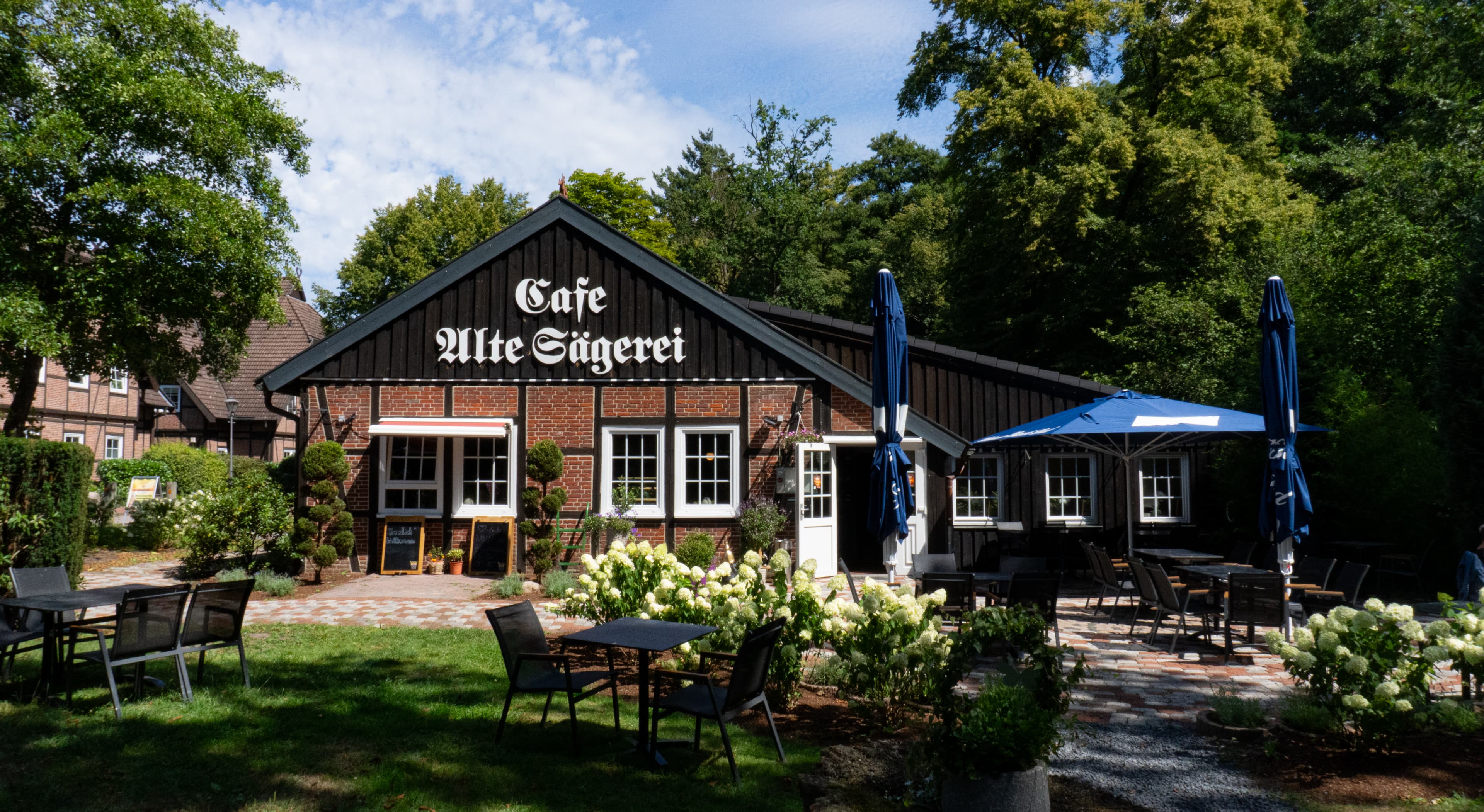Außenansicht des Café Alte Sägerei in Jesteburg mit Garten und Terrasse