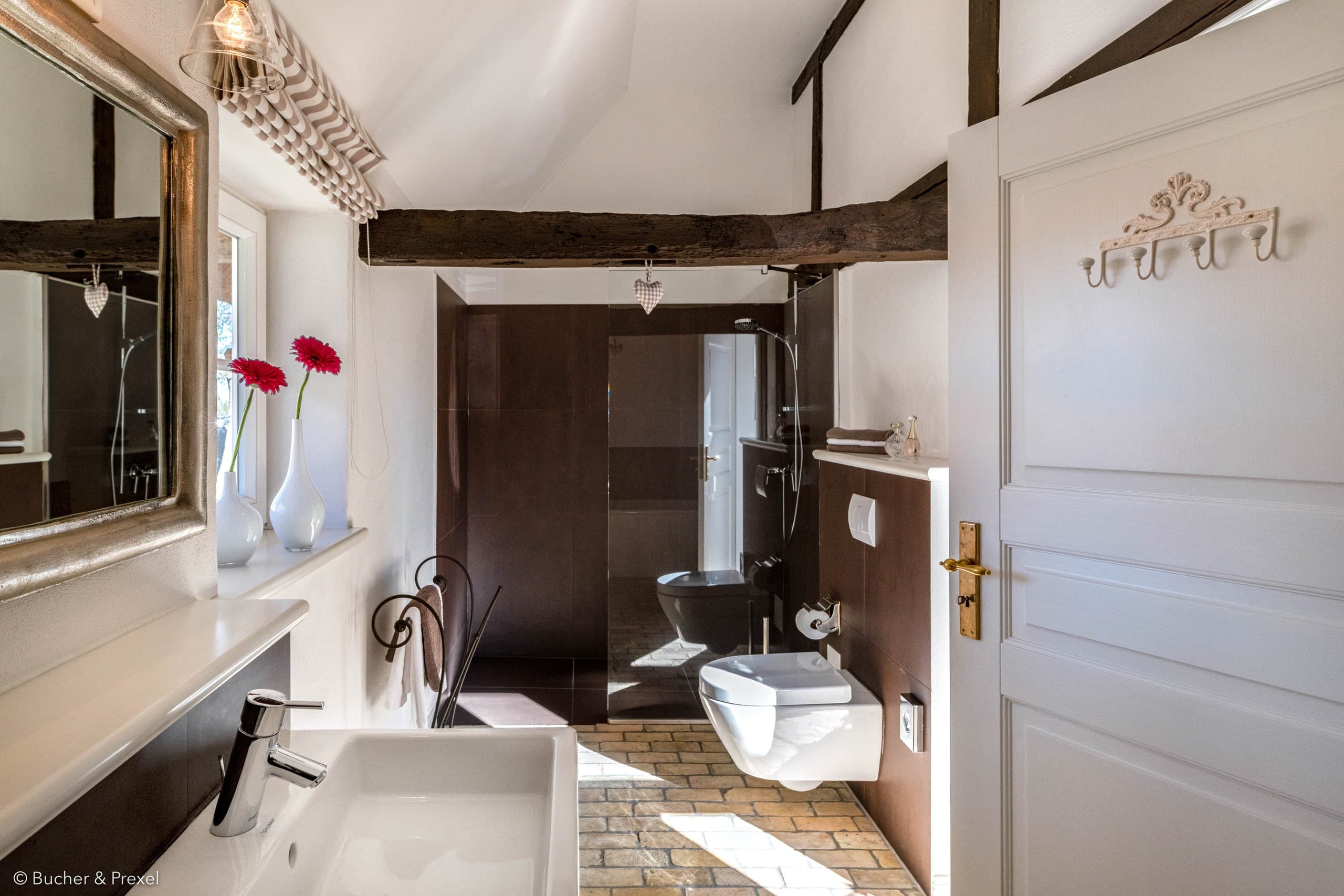 Badezimmer mit Waschbecken, bodengleicher Dusche und Holzbalken in Apartment I