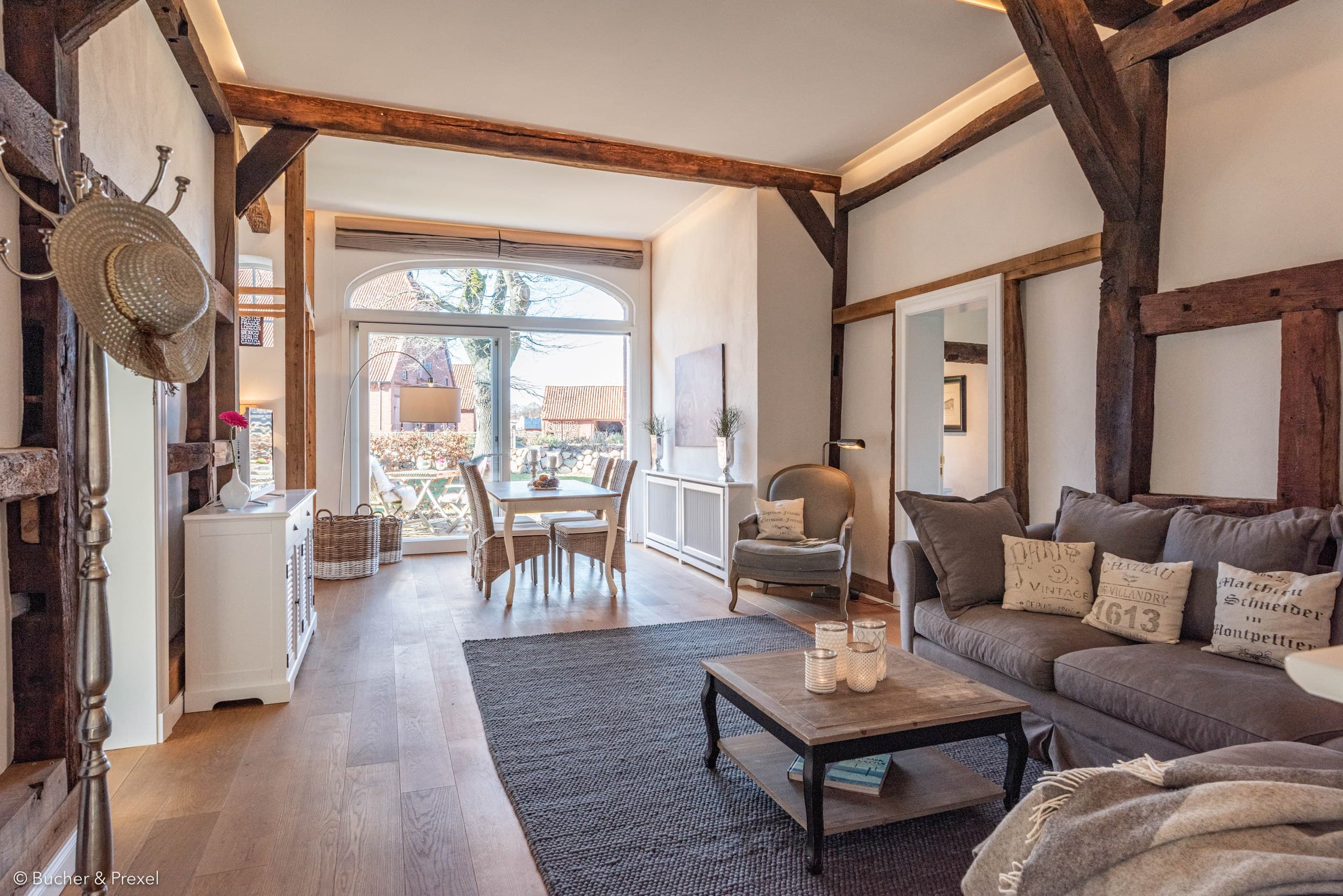Großer Wohn- und Essbereich mit Fachwerk, Sofa und Esstisch vor der Terrassentür in Apartment V