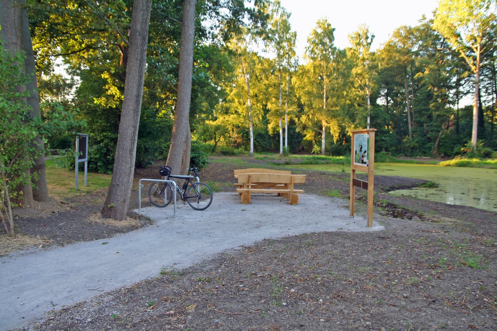 Rastplatz mit Tisch, Bänken und Fahrradabstellbügeln an den renaturierten Wierener Dorfteichen