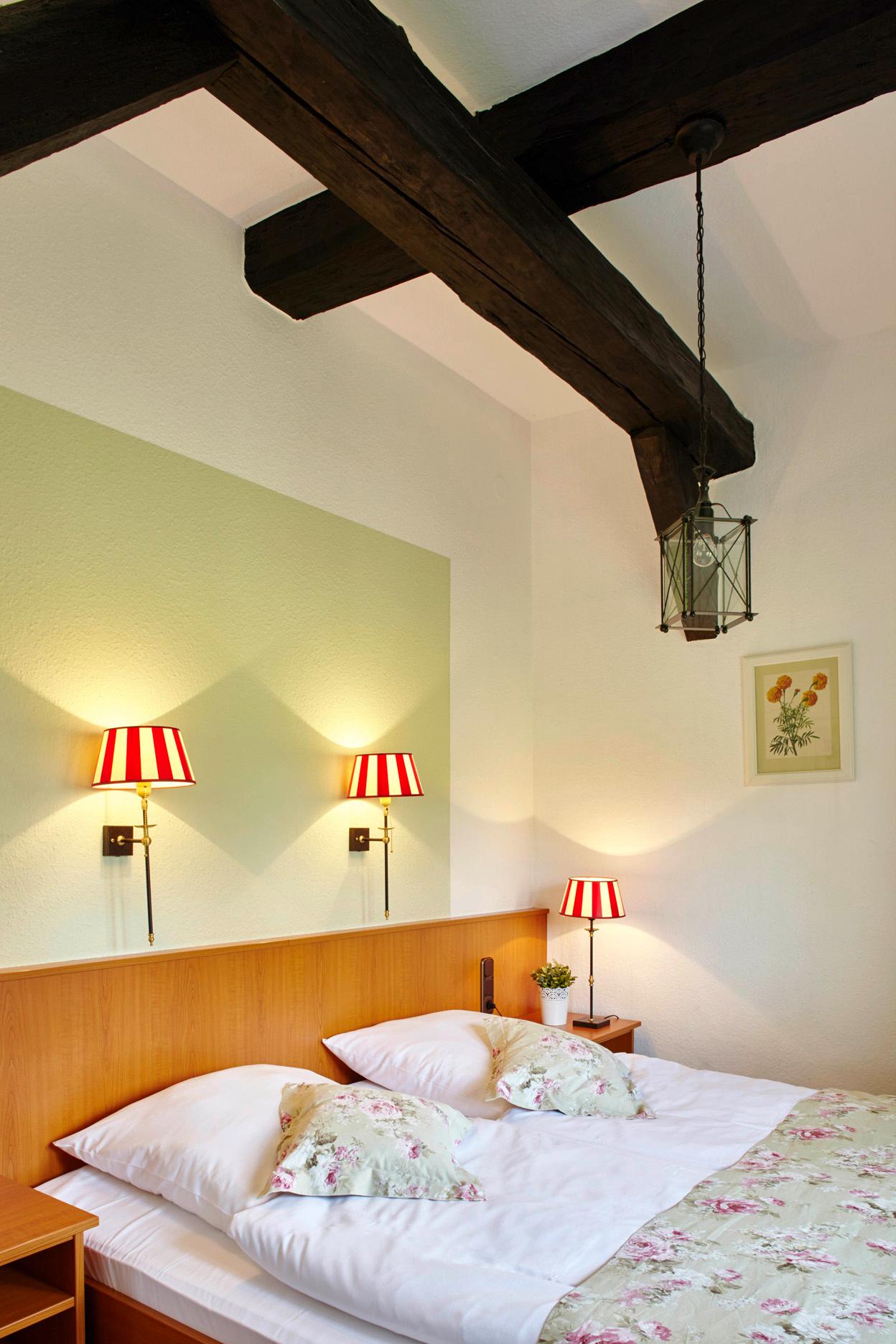Bett in einem der Doppelzimmer des Naturotel Landhaus Haverbeckhof in Bispingen