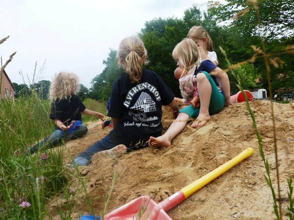 Ein großer Sandberg vor dem Pferdestall läd zum Spielen ein