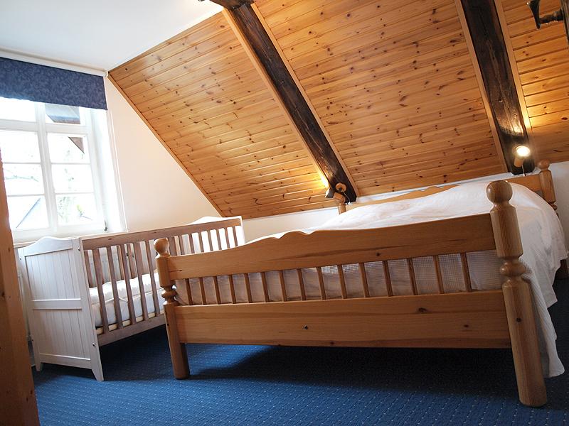 Schlafzimmer mit Kinderbett Ferienwohnung Alte Bauernkate  "Heuboden"