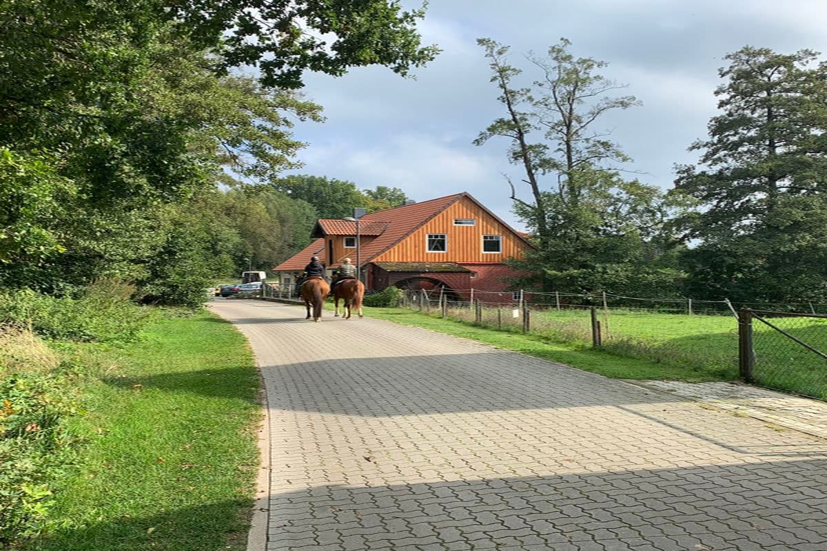 Reiter vor der Außenansicht der Ferienwohnung Wassermühle in Eschede
