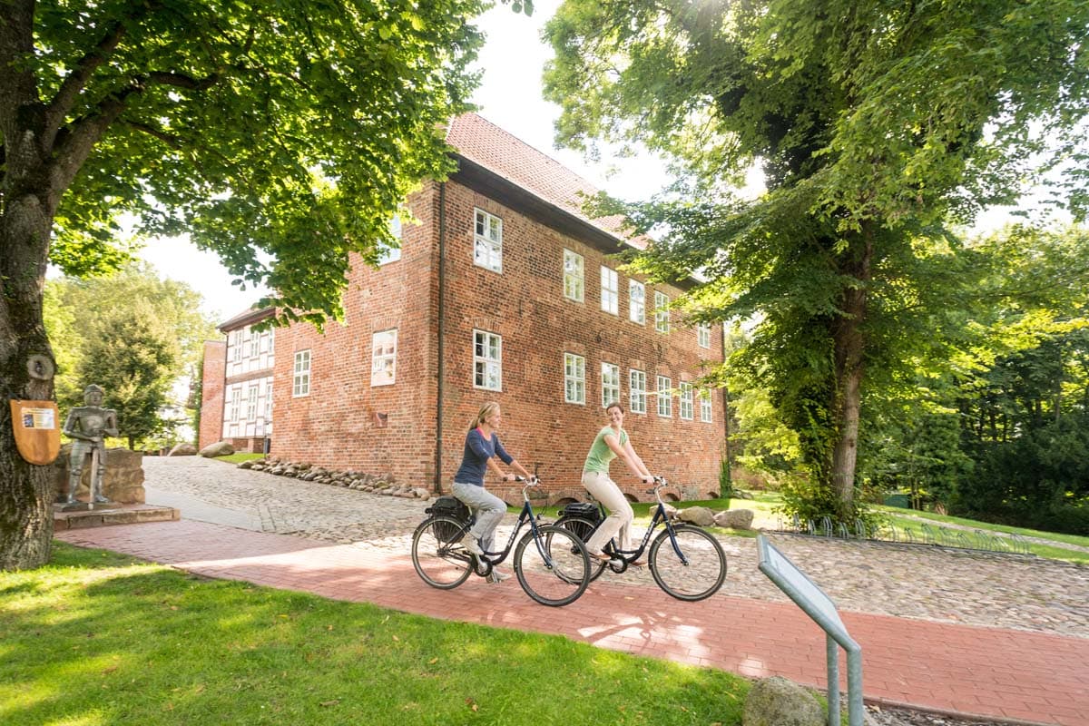 Radfahrerinnen vor der Burg Bodenteich