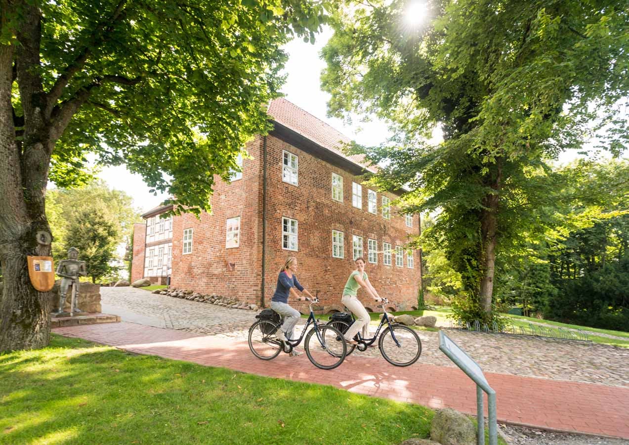 Radfahrer an der Burg Bodenteich in Bad Bodenteich in der ADFC-RadReiseRegion Uelzen in der Lüneburger Heide